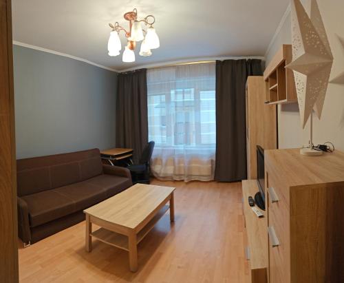 een woonkamer met een bank en een tafel bij Cozy 1-bedroom apartment in the heart of Jurmala in Jūrmala