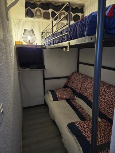 a room with two bunk beds and a television at studio 4 pers Puy-Saint-Vincent 1700 in Puy-Saint-Vincent