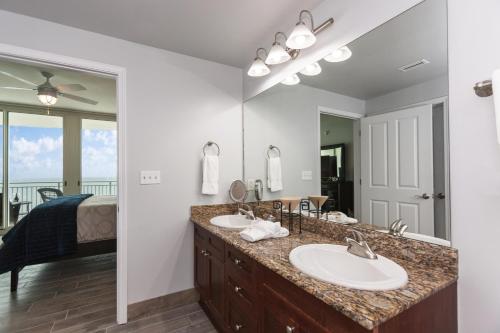 a bathroom with two sinks and a large mirror at Aqua 801 in Panama City Beach