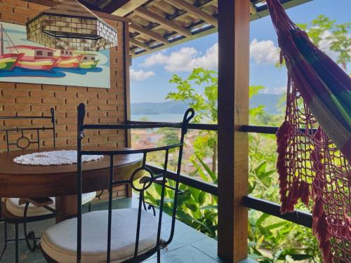a balcony with a hammock and a view of the ocean at Pousada Morro do Forte in Paraty