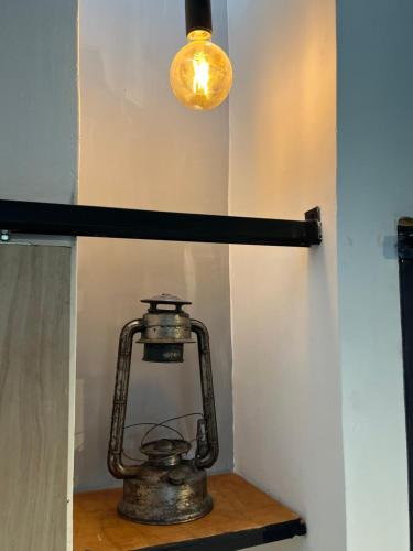 a lantern sitting on a shelf under a light at Apartamento rústico industrial , enfrente de hotel prado in Barranquilla