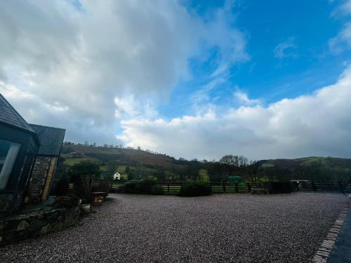 a view of a house with a hill in the background at The Retreat in Llanrhaeadr-ym-Mochnant