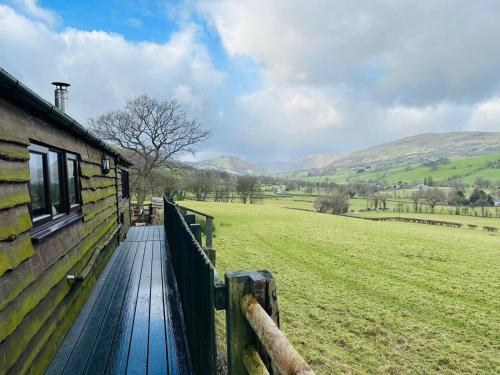 a wooden walkway next to a building and a field at The Retreat in Llanrhaeadr-ym-Mochnant