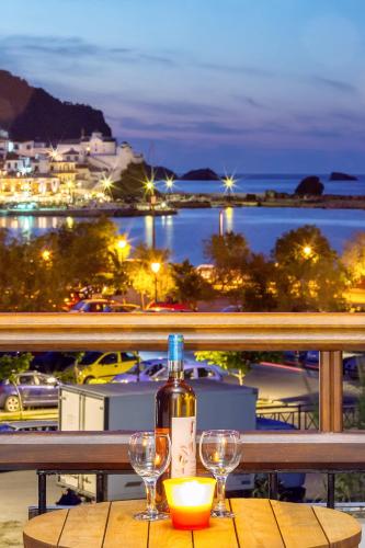 a bottle of wine sitting on a table with two glasses at Akti Fine Rooms in Skopelos Town
