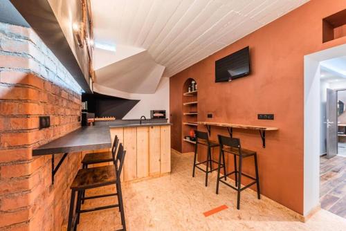 une cuisine avec un bar avec des tabourets et un mur en briques dans l'établissement Logement-sauna-spa-Strasbourg-Colmar-Europa Park, à Benfeld