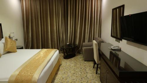 a hotel room with a bed and a flat screen tv at فندق جوافة اللوتس in Najran