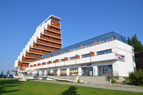 a large white building with a lot of windows at Apartman Panorama 213, Štúdio Comfort in Štrbské Pleso