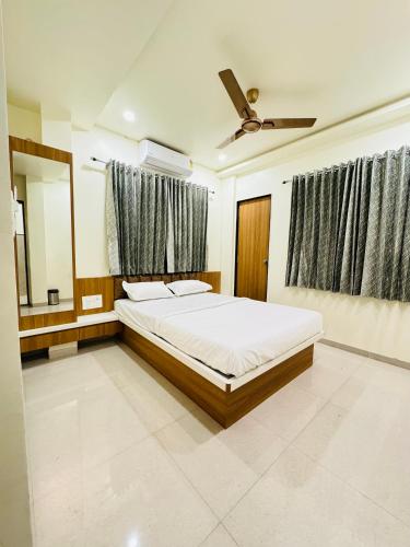 1 dormitorio con 1 cama y ventilador de techo en HOTEL EKANT FAMILY RESTAURANT AND LODGING, en Daulatābād