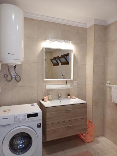 uma casa de banho com uma máquina de lavar roupa e um lavatório em Happy Heart Los Molinos em Costa Teguise