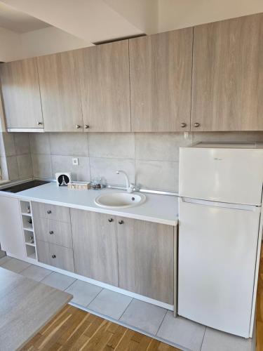 a kitchen with a sink and a white refrigerator at EApartments in Skopje
