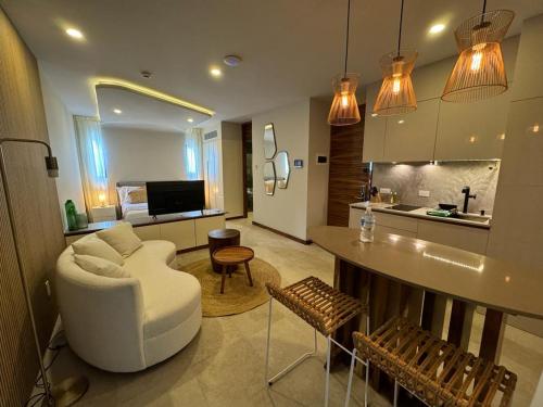 a living room with a white couch and a kitchen at Alizee Tower in Playa del Carmen
