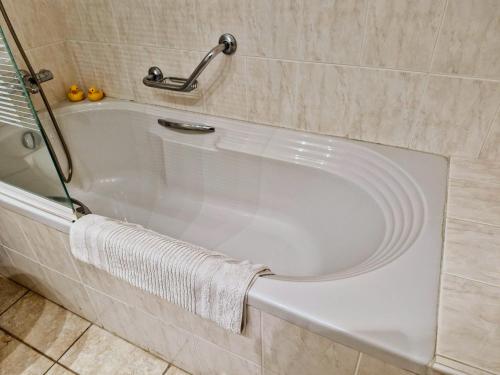 a white bath tub in a bathroom with a towel at Givon Palace in Paphos City
