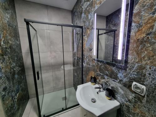 a bathroom with a glass shower and a sink at Villa Międzyzdroje in Międzyzdroje