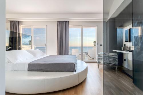 1 dormitorio con 1 cama blanca grande y ventana grande en Hibrido Boutique Hotel & Spa, en Sciacca