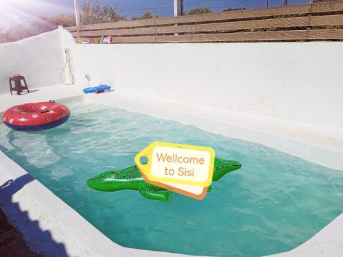 um sinal que diz bem-vindo a sentar-se numa piscina em Boho Sisi Resort em Sissi