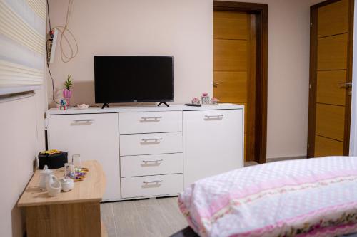 una camera da letto con un comò bianco con una televisione di Big Lale UR a Bijeljina