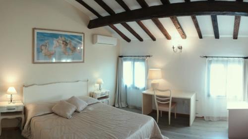 a bedroom with a bed and a table and chairs at Villa Cittadella B&B in Mantova