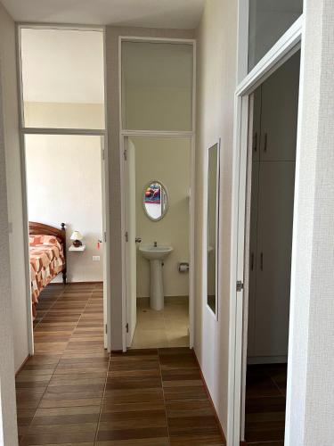 a hallway with a bathroom with a sink and a bed at Comfortable Appartment with Free Parking in Tarapoto