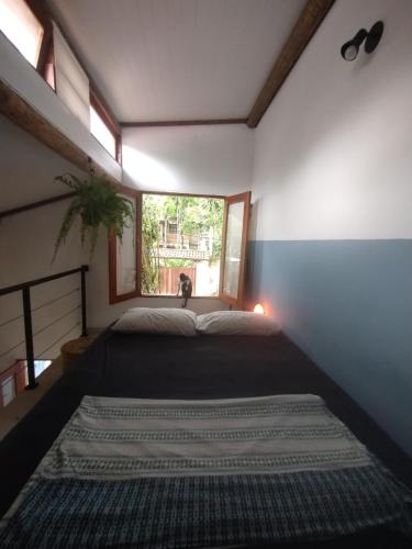 1 dormitorio con cama y ventana en Chalé Mar Aberto, en Porto Seguro