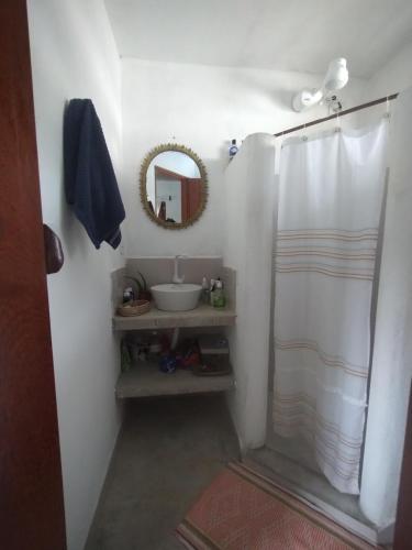 a bathroom with a shower with a sink and a mirror at Chalé Mar Aberto in Porto Seguro