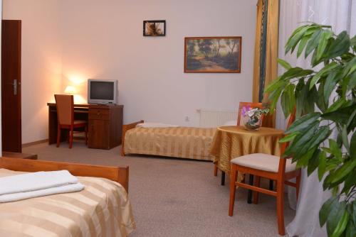 a hotel room with two beds and a desk at Hotel Pod Dębami in Terespol