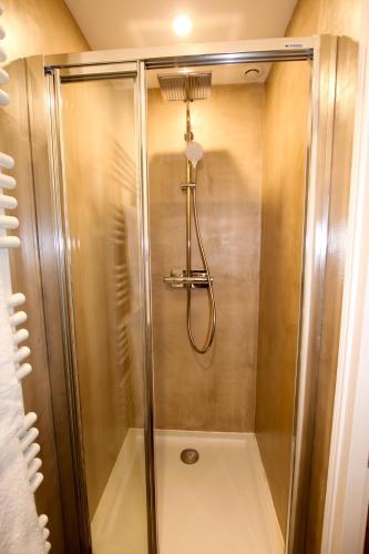 une douche avec une porte vitrée dans une salle de bain dans l'établissement REIMS-ESCAPADE Gallery, à Reims