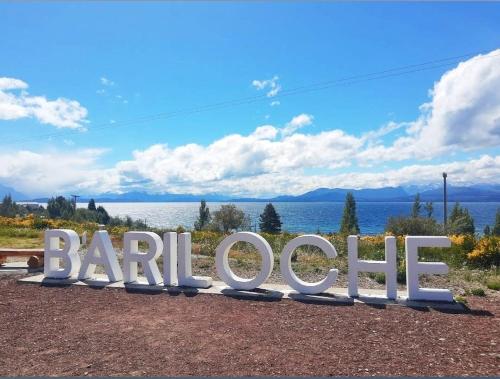 a large sign that reads barilote in front of the water at Las Victorias Suites Bariloche in San Carlos de Bariloche
