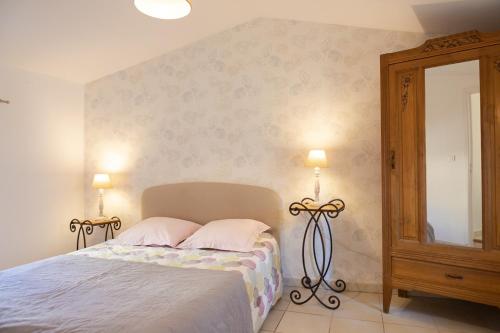 a bedroom with a bed with two lamps and a mirror at Appartement spacieux Rochereau in LʼIsle-sur-la-Sorgue