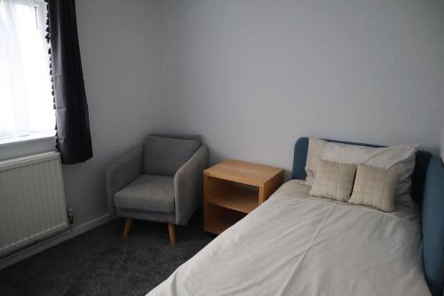 1 dormitorio con 1 cama y 1 silla en Charming 3Bed Home in High Barnet, en Barnet