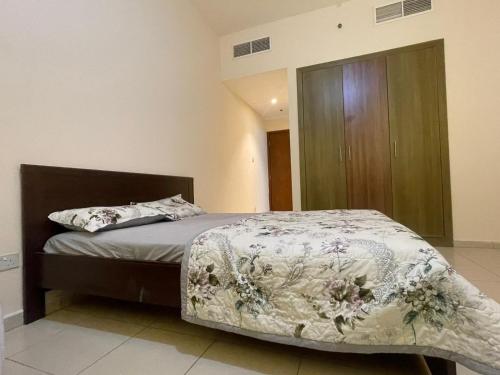 um quarto com uma cama e um armário de madeira em Holiday Home Master bed room in Ajman city UAE em Ajman