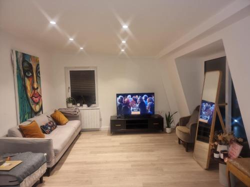 a living room with a couch and a flat screen tv at Beckenham- Stunning Double Bedroom With En-suite in SHARED APARTMENT in Elmers End