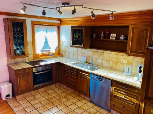 a kitchen with wooden cabinets and blue appliances at Ferienhaus Schweissing in Fröhnd