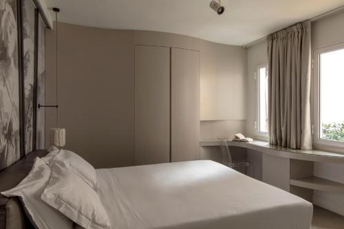 1 dormitorio con cama blanca y ventana en BDB Rooms Navona en Roma