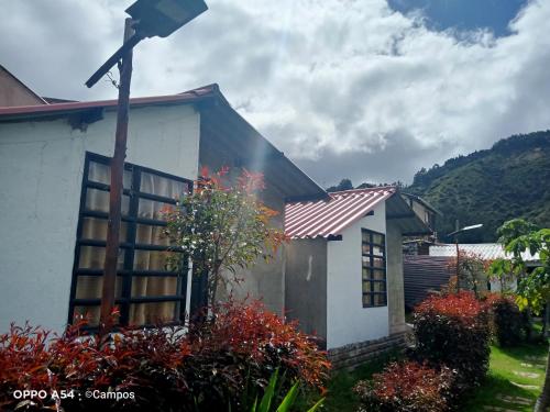 a house with a cross on the side of it at CASA BAHAREQUE HOSPEDAJE in Monguí