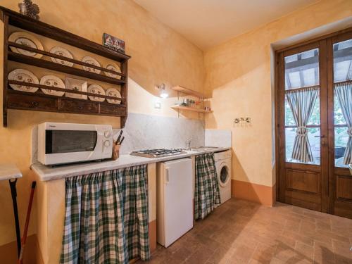 a kitchen with a microwave and a stove at Agriturismo Mulinaccino in Fabro