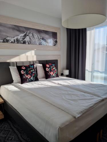 a bedroom with a large bed with pillows at Villa Olimpijska 2 - Centrum in Wisła