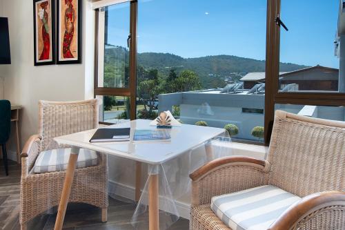 Biały stół i krzesła w pokoju z oknem w obiekcie Pearl White Sands w mieście Glentana