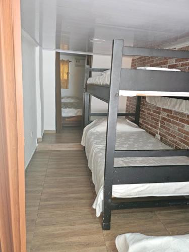 a room with two bunk beds and a brick wall at El Hostal By Pochet in San Andrés