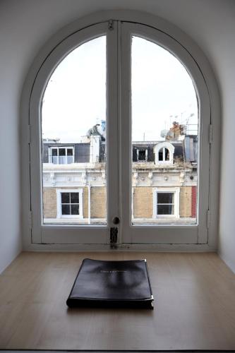 a yoga mat in front of an open window at Dreamtel London Kensington in London