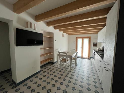 cocina y comedor con mesa y sillas en Appartamento Fronte Laguna Ca’Nonica en SantʼAntonio