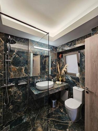 a bathroom with a toilet and a sink and a shower at Cozy & Minimal Apartment Near Airport Peania in Paianía