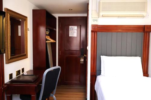 a bedroom with a desk and a bed and a bed and a desk at Dreamtel London Kensington in London