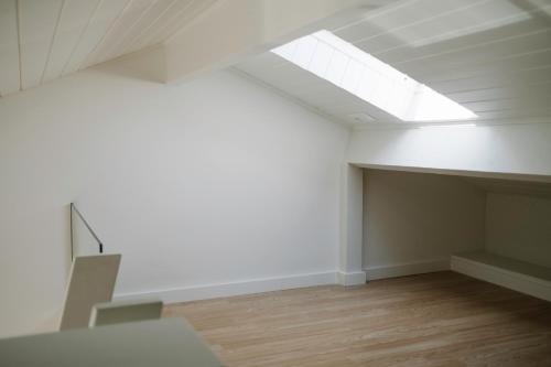 an empty white room with a skylight in the ceiling at Aldoar House in Porto