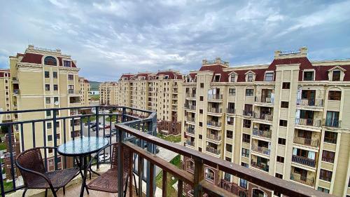 einen Balkon mit einem Tisch, Stühlen und Gebäuden in der Unterkunft cozy apartament with sea view in Tbilisi City