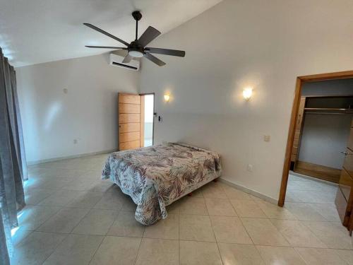 een slaapkamer met een bed en een plafondventilator bij Casa Sirena 18 in Manzanillo