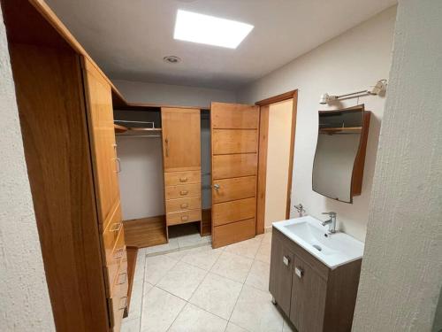 ein Badezimmer mit einem Waschbecken und einigen Holzschränken in der Unterkunft Casa Sirena 18 in Manzanillo