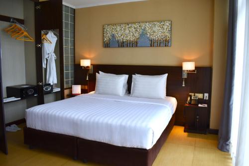 sypialnia z dużym łóżkiem z białą pościelą w obiekcie Swiss-Belinn Nairobi w mieście Nairobi
