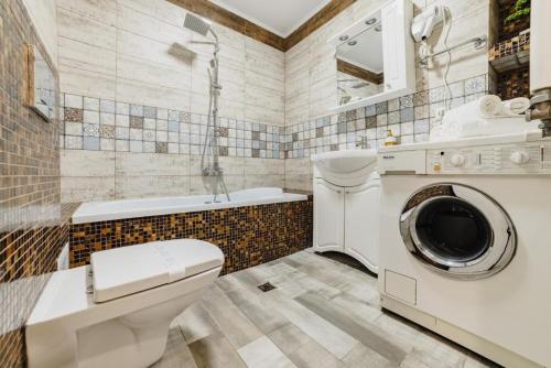 a bathroom with a toilet and a washing machine at Luxury Apartment Oasis in Timisul de Jos