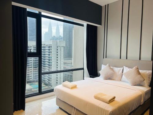 um quarto de hotel com uma cama com uma grande janela em AXON RESIDENCE KLCC BY JD em Kuala Lumpur