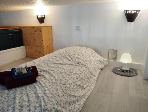 ein Schlafzimmer mit einem großen Bett und Holzboden in der Unterkunft Le Studio de la Seine in Elbeuf